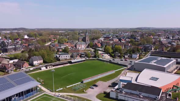Aerial View over the village, the church, the soccer field and the swimming pool of Merelbeke