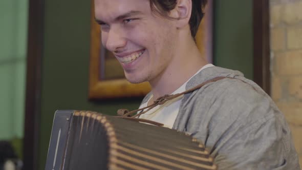 Skill Young Man Playing the Accordion Smiling