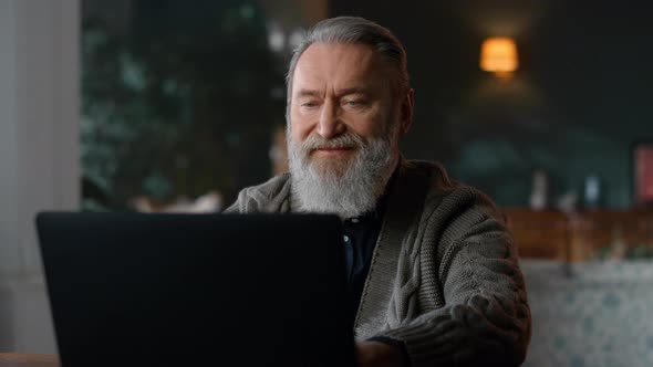 Senior Business Man Using Laptop in Cozy Living Room