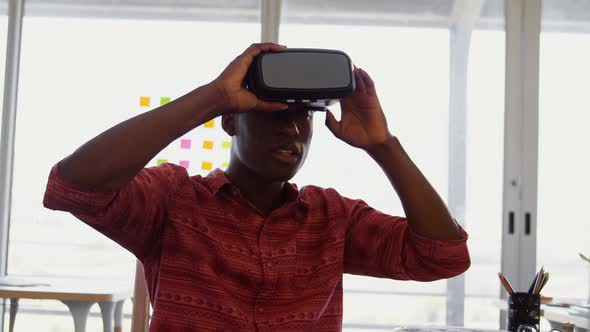 Front view of African American male graphic designer using virtual reality headset art desk in offic