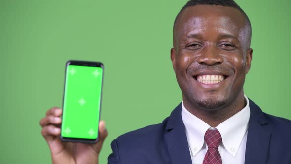 Young Happy African Businessman Showing Phone