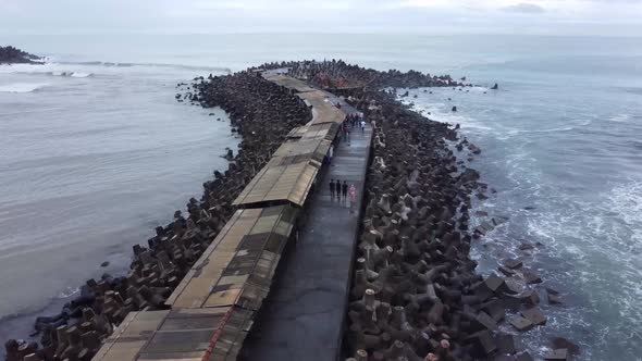 Aerial view of sea wave crashing tetra concrete block or wave breaker stone at Glagah beach, Indones