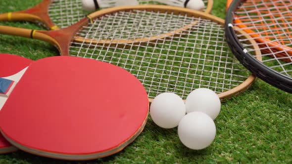 Sport Equipment Rackets and Balls on Grass Background