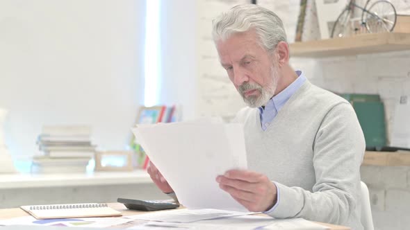 Old Man Calculating Finance and Working on Documents