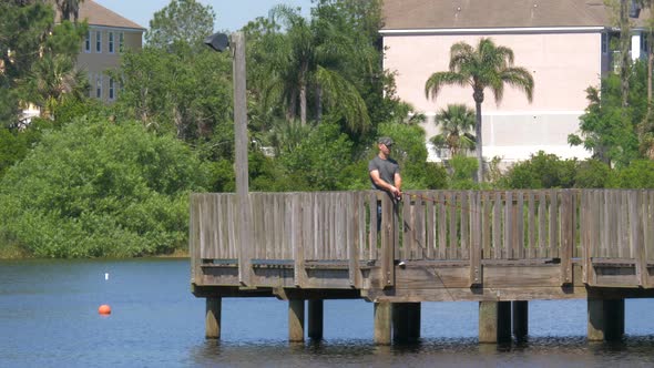 Fishing with Spinning Tackle on Wooden Pier