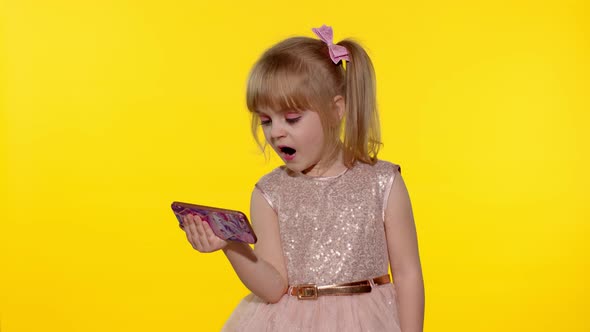 Child Girl Using Smartphone. Kid Looking at the Screen of a Mobile Phone, Watching Cartoons