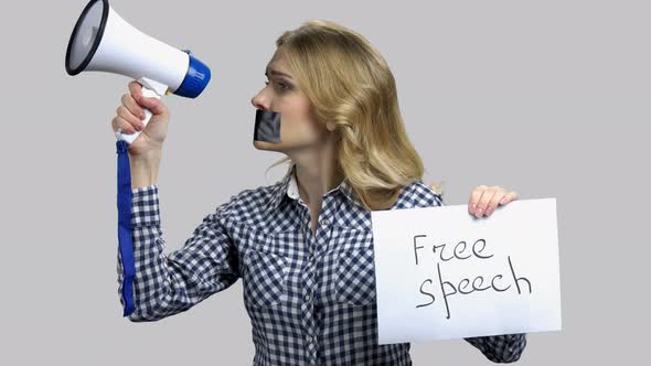 Young Woman Tries To Speak in Megaphone with Taped Mouth