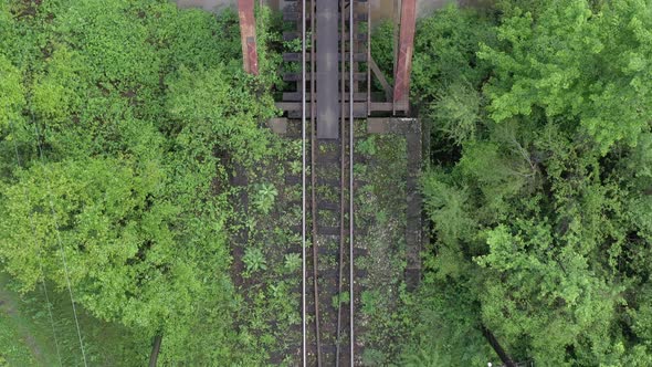 Looking down to railway track on rusty bridge 4K aerial video