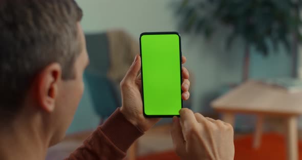 Middle Aged Man Holding Smartphone with Green Screen