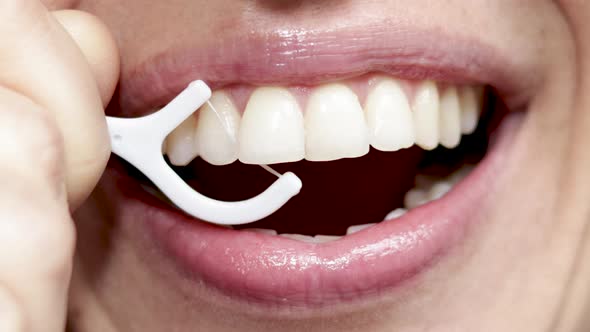 close up4 k video woman mouth smiling and flossing her teeth with white plastic toothpick. beautiful