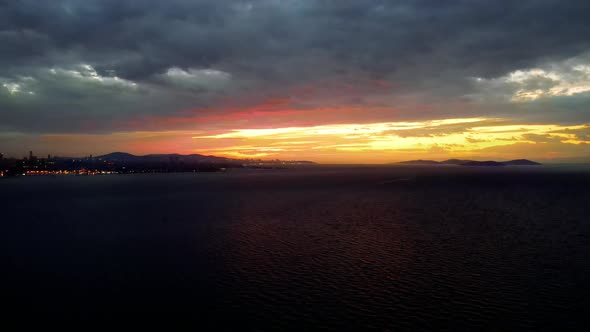 aerial view of sunrise in the city  , above sea in cloudy winter day