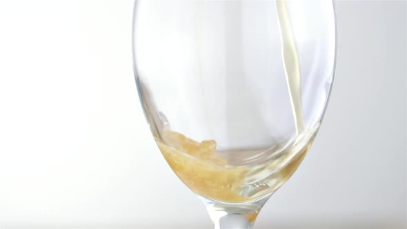 Slow Beer Tapping, Detail of Draft Golden Beer into a Wine Glass on White Background