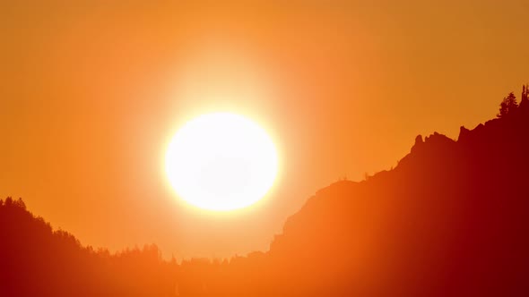 Time lapse of the sun rising from mountains