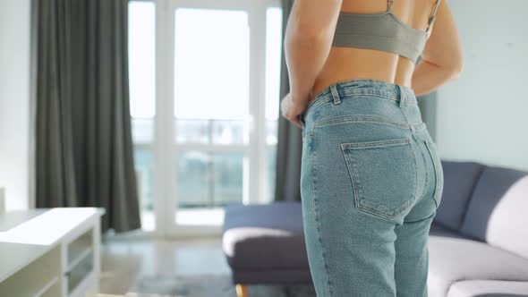 Woman Pulls Her Jeans Over Her Buttocks