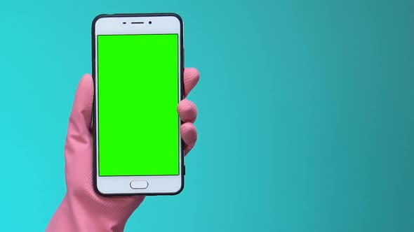 Females Hand in Gloves Showing Smartphone With Green Screen, Cleaning Service