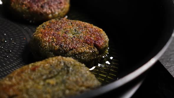 Close up slow motion of falafels frying on pan.