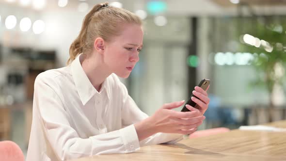 Disappointed Young Businesswoman Having Loss on Smartphone 