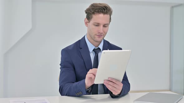 Hardworking Young Businessman Using Tablet in Office