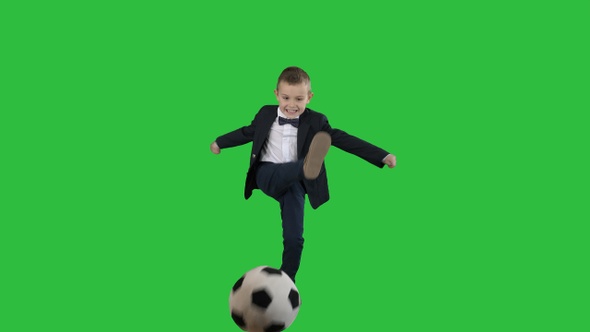 Little Boy In Costume Shooting at Goal on a Green Screen