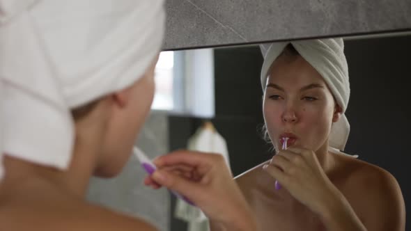 Caucasian woman brushing teeth in hotel