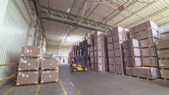 Forklift truck pulled up to a pile of wooden pallets. Large industrial enterprises department