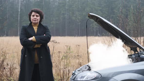 Sad Woman Standing on the Road By the Broken Car