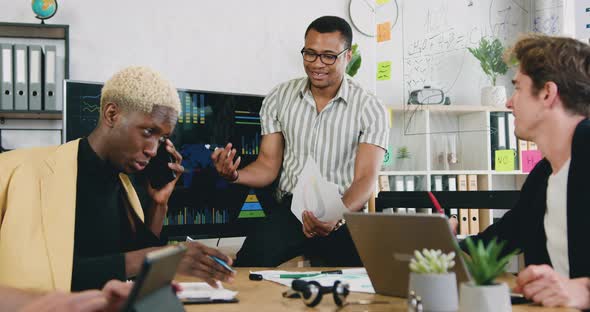 Busy Male, Talking, Working Together at Workplace, Using Electronic Whiteboard, Paper documents