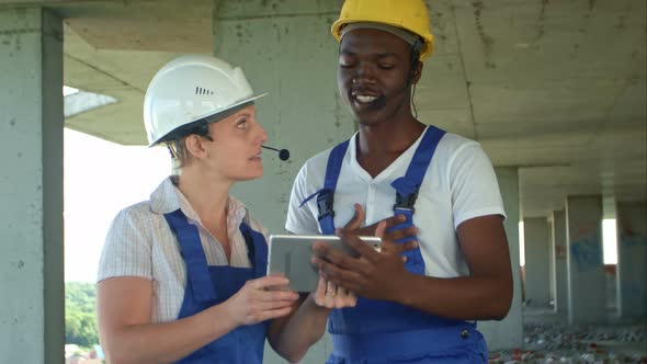 Engineers on Building Site Using Digital Tablet and Talking