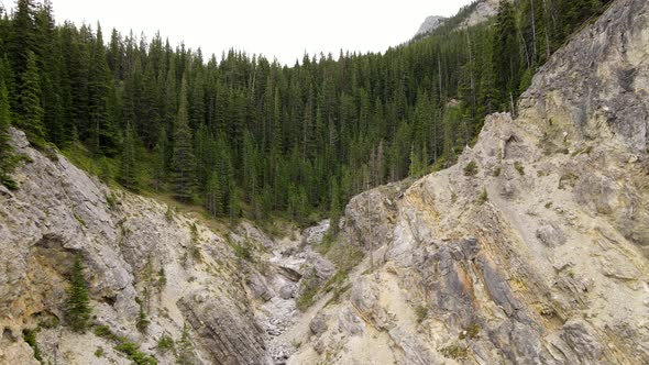 Slowly forwarding aerial footage in 4k approaching steep rocky gorge in front of vast and untouched