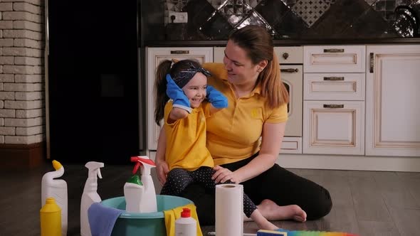 A Little Girl Helps Her Mother Clean the House She Wears Big Rubber Gloves