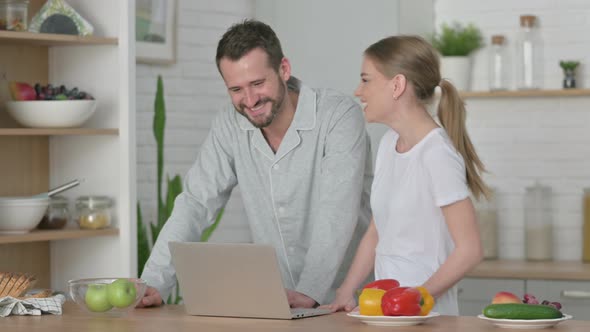 Woman and Man Doing Video Call on Laptop in Kitchen