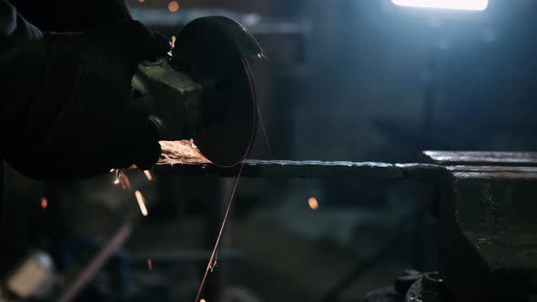 Man in Gloves Cuts Metal with a Circular Saw, a Lot of Sparks. The Working Process. Work with Metal