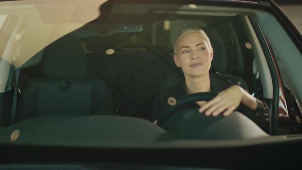 Woman Smiling in Her New Car in a Showroom