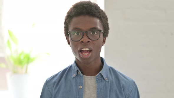 Portrait of Excited Young African Man Celebrating Success