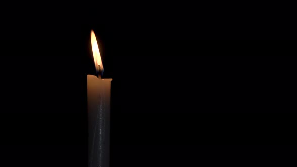 A single white candle burning.