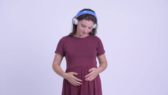 Happy Young Beautiful Pregnant Woman Listening To Music