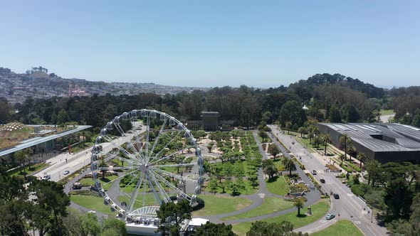 Aerial shot flying by the SkyStar Ferris Wheel towards the Spreckles Temple of Music bandshell in th