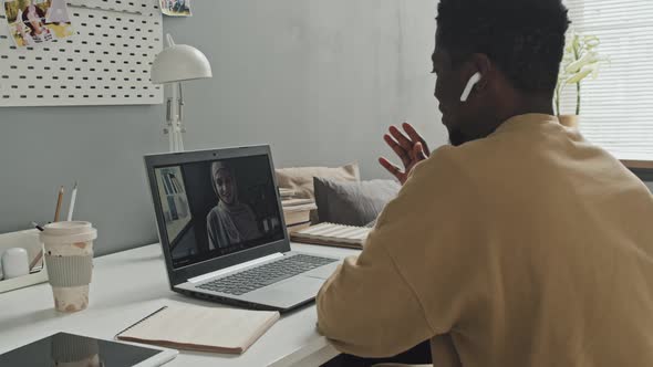 African American Man Having Online Lesson with Muslim Teacher at Home