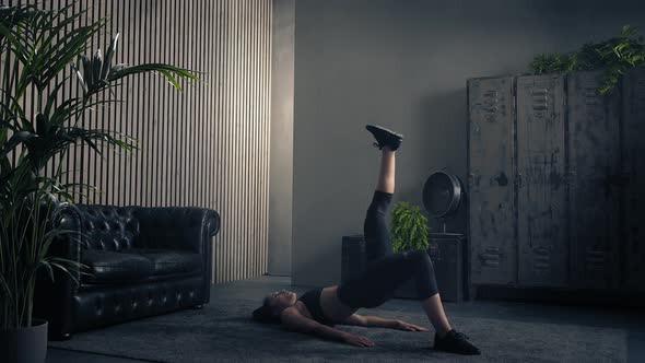 Athletic Brunette Woman Doing Single Leg Glute Bridge Indoor in Sportswear