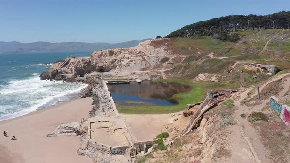 Close-up descending and panning aerial shot of the ruins of the Sutro Baths at Land's End in San Fra