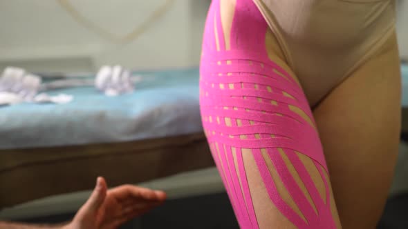Physiotherapist Applying Kinesio Tape on Female Patient