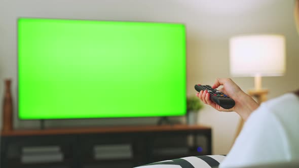 TV Green Screen in living room with tree and lamps. woman sit on sofa watch movie in house