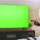 TV Green Screen in living room with tree and lamps. woman sit on sofa watch movie in house - VideoHive Item for Sale