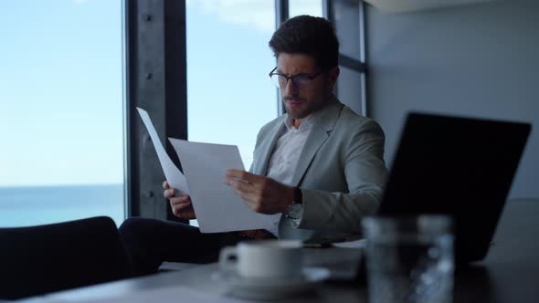 Businessman Studying Documents Papers in Office