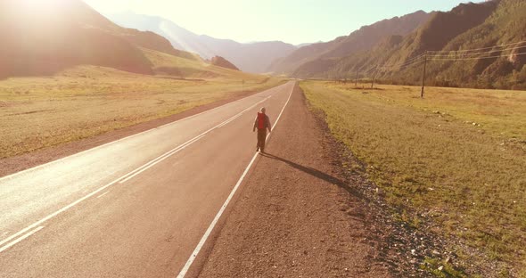 Flight Over Hitchhiker Tourist Walking on Asphalt Road