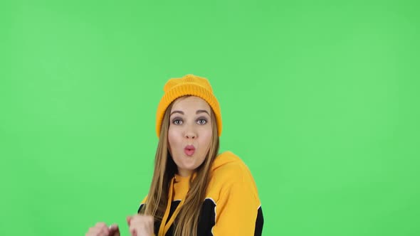 Portrait of Modern Girl in Yellow Hat Is Dancing Funny. Green Screen