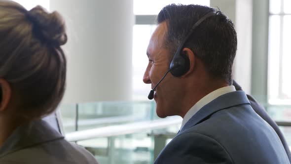 Business people wearing headsets in a modern office