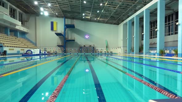 Turning Off Lights in Empty Pool with Clear Water and Dividers Track for Swimming. Blue Water in