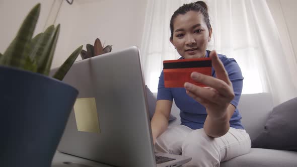 Asian businesswoman are using cards to pay for online shopping on a laptop