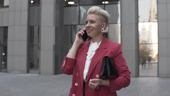 Attractive stylish blonde woman making a phone call to a business contact